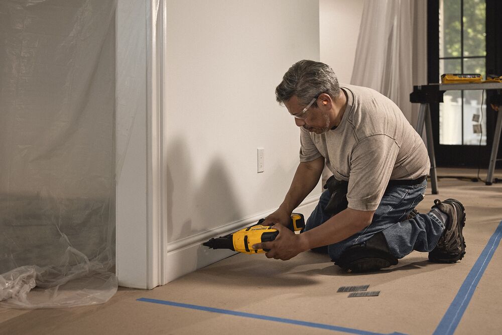 A tradesperson uses a DEWALT nailer to secure trim pieces