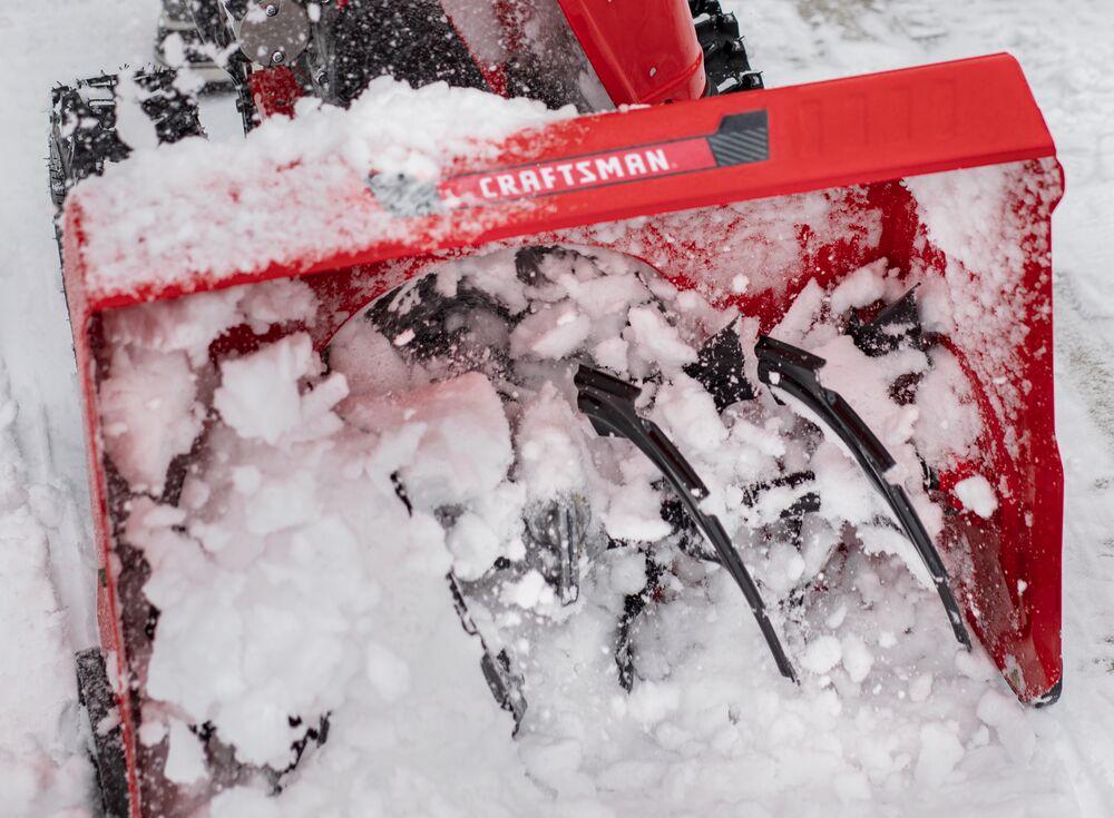 CRAFTSMAN Gas Snow Blower with Push-Button Electric Start close up of scraper blades plowing snow