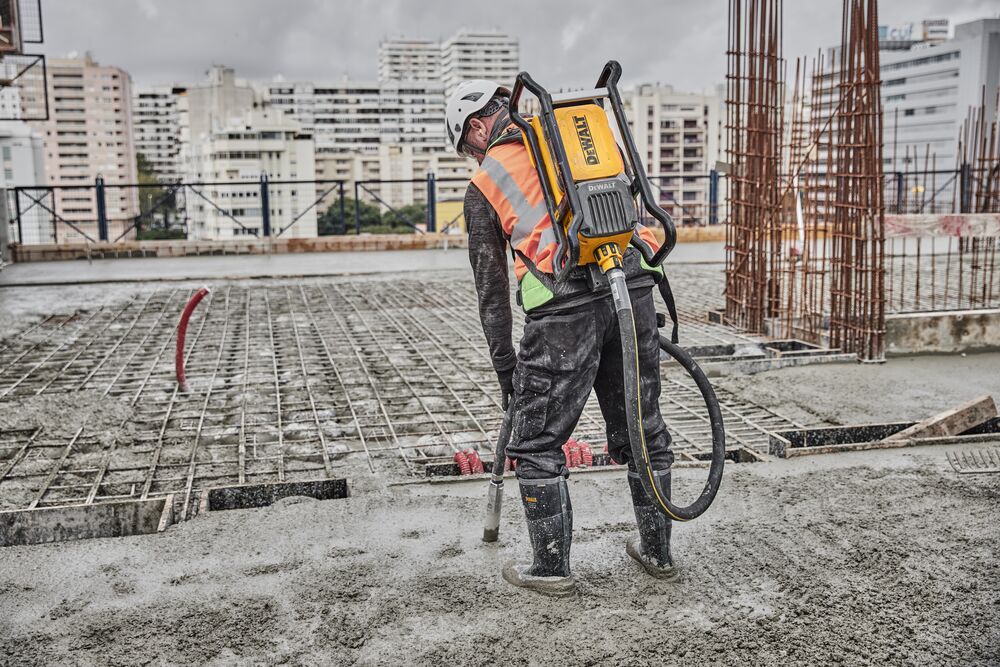 Construction working concrete pouring using Powershift Backpack Concrete Vibrator and hose