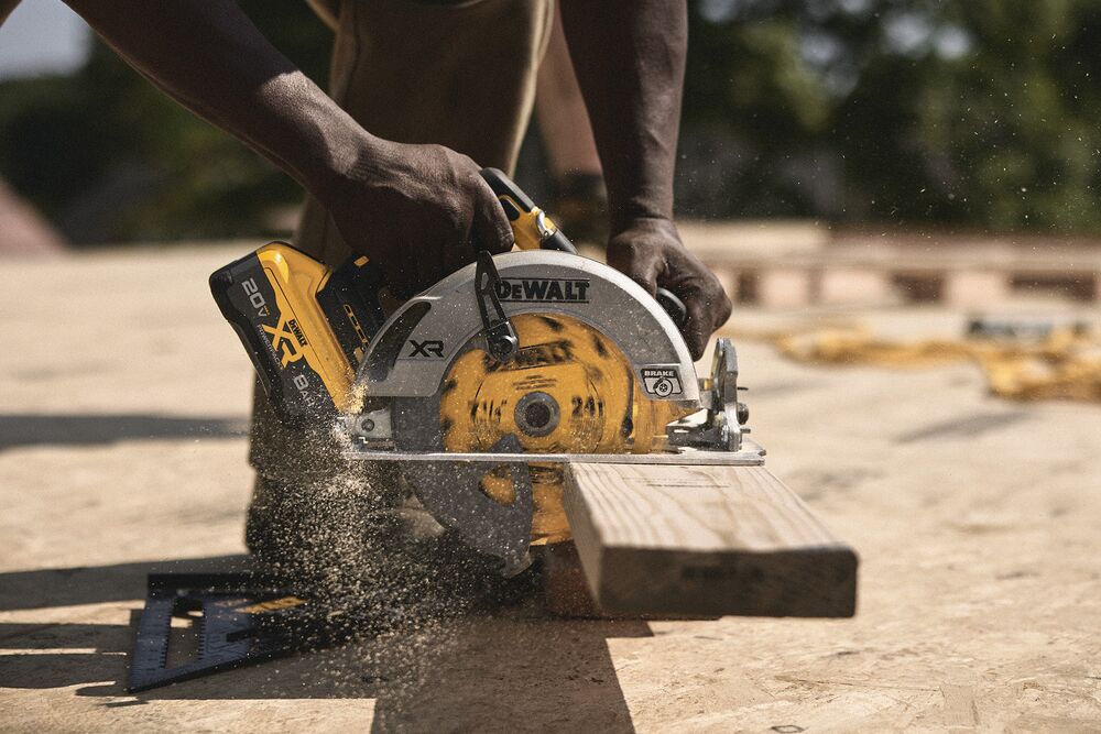 A tradesperson uses a DEWALT circular saw to cut a piece of wood