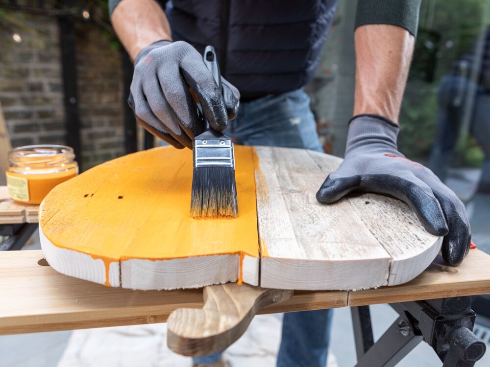 A wooden pumpkin being painted.