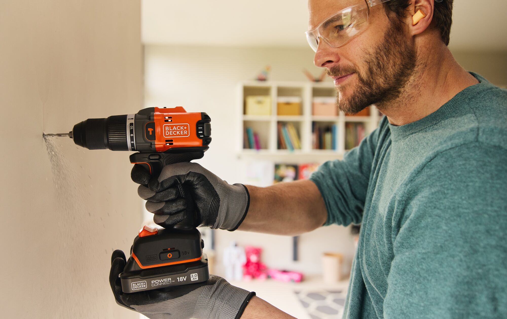 A man drills into an interior wall using the BLACK+DECKER® 18V POWERCONNECT™ Brushless Drill Driver.