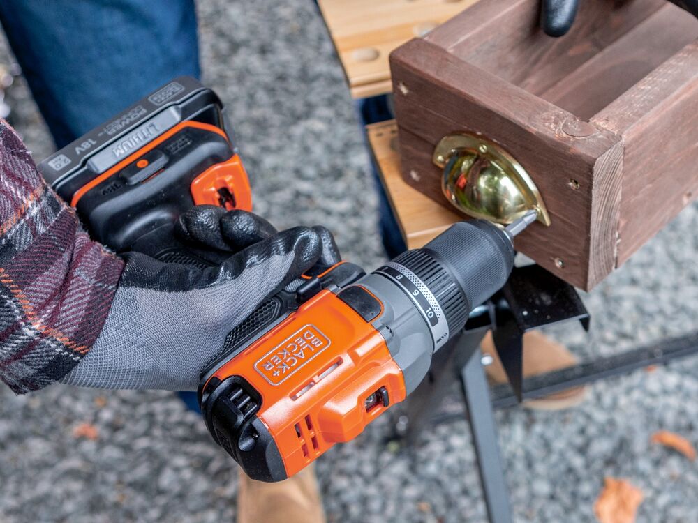 A handle being screwed to a wooden candle holder with the BLACK+DECKER POWERCONNECT 18V Cordless Drill Driver.