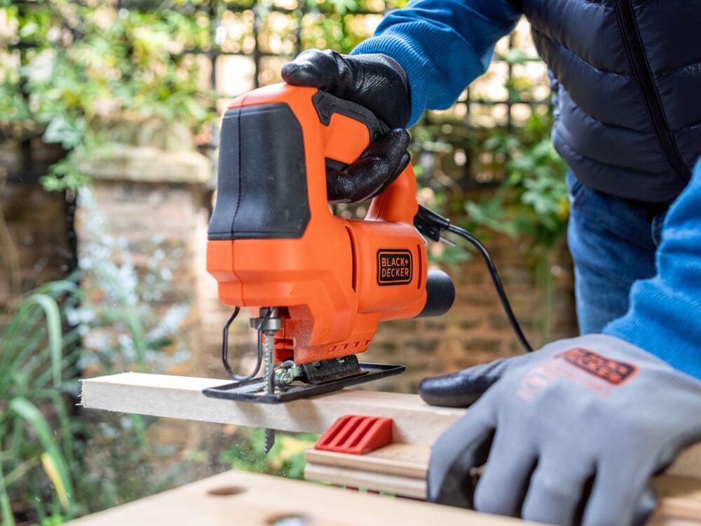 A wooden plank being sawn with the BLACK+DECKER 400W Single Speed Jigsaw.