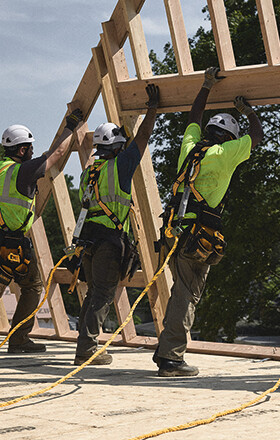 Three tradespeople hoist up a frame