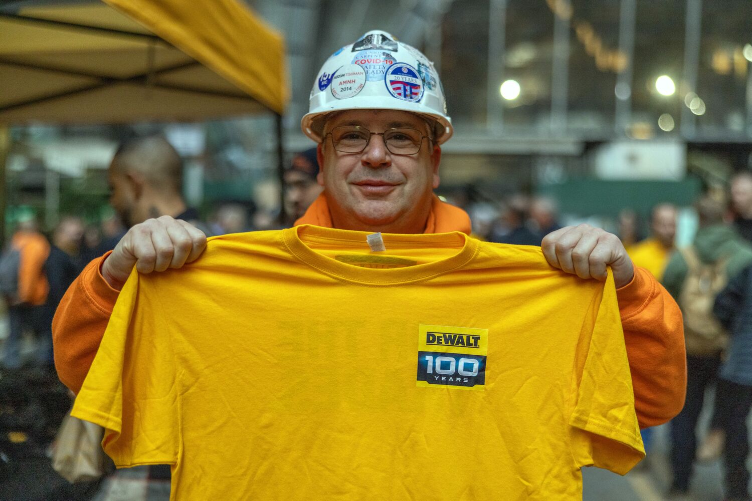 Tradesman holding a DEWALT For The Trades t-shirt on a NYC Job Site