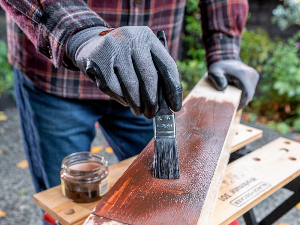 Varnish being applied to a wooden candle holder.