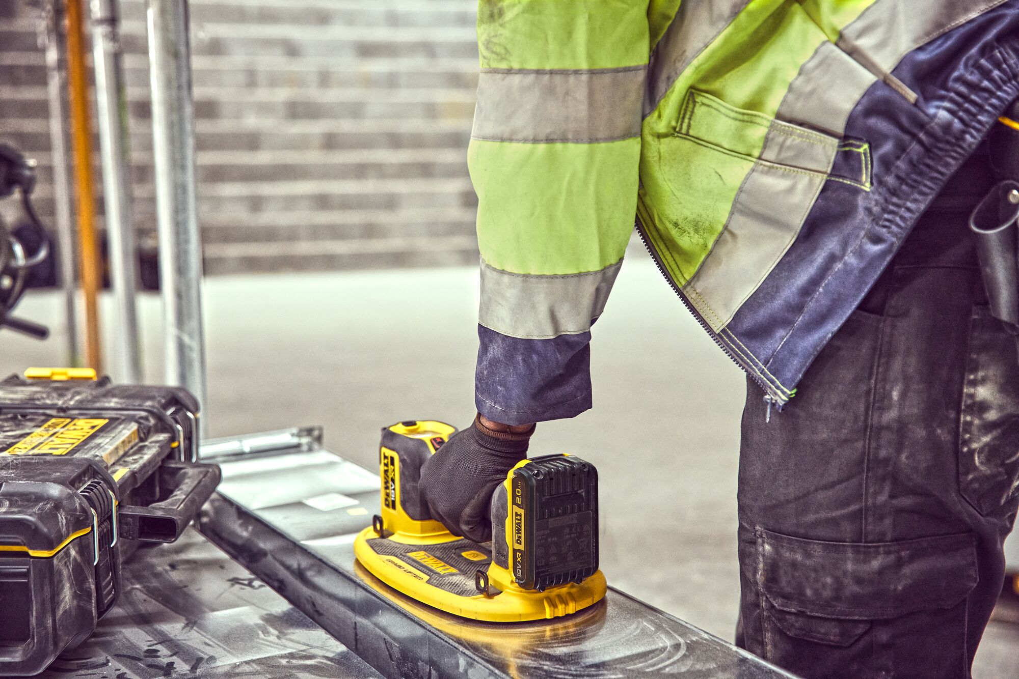 Arm shot of construction worker using the Grabo 18V XR Suction Lifter to lift metal duct frame work