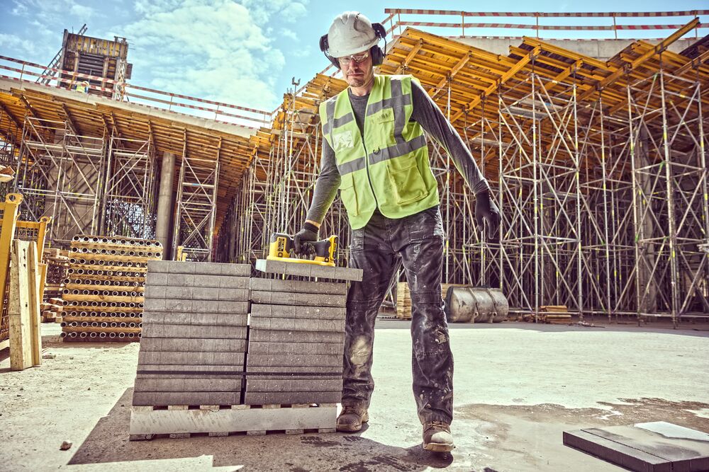 Construction worker uses a Grabo 18V XR Suction Lifter to lift a concrete block