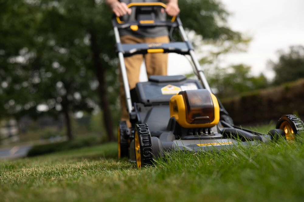 Front view of a 54V self propelled 53cm lawn mower cutting grass