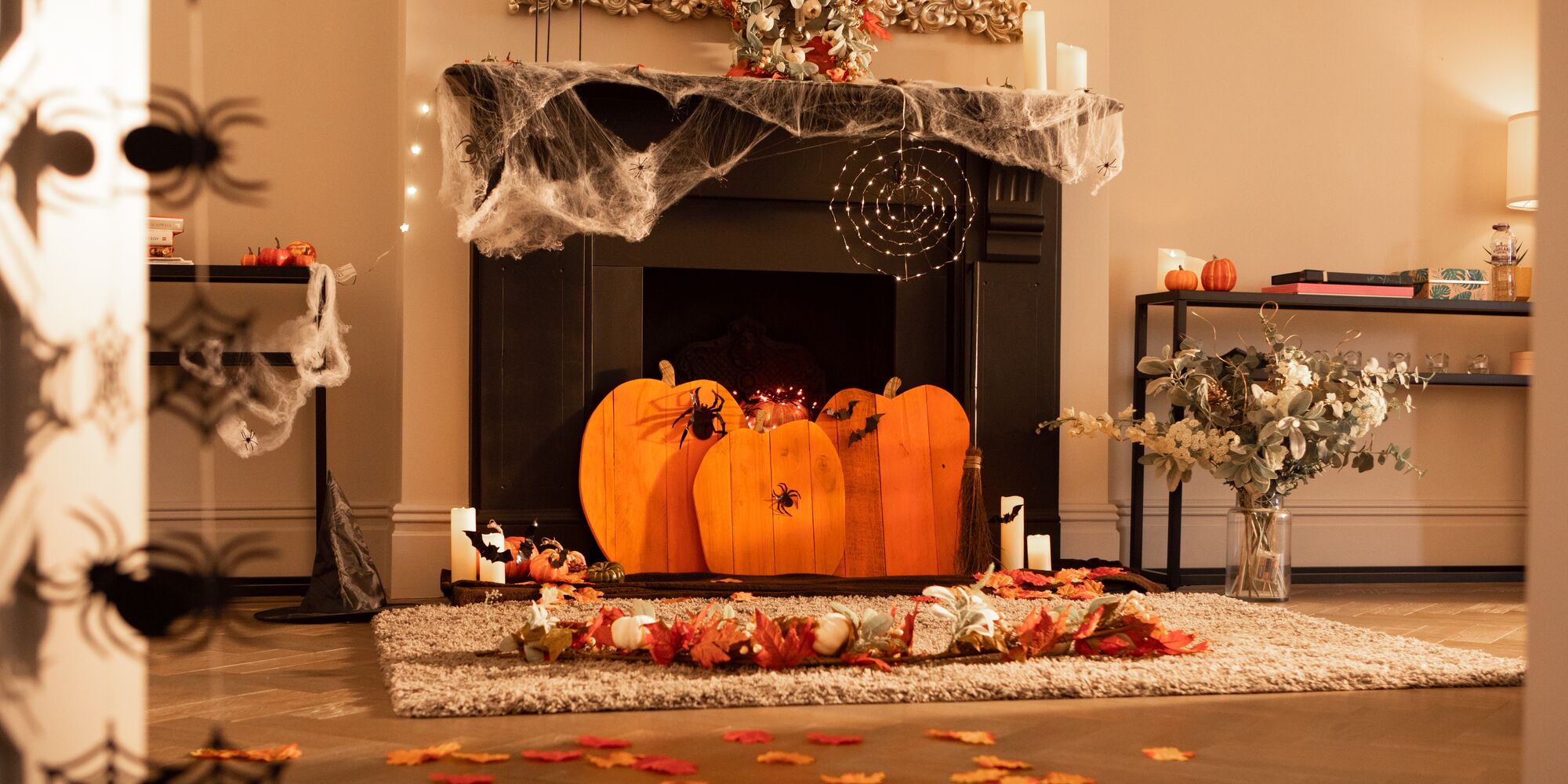 Wooden pumpkins in front of a spookified fireplace.