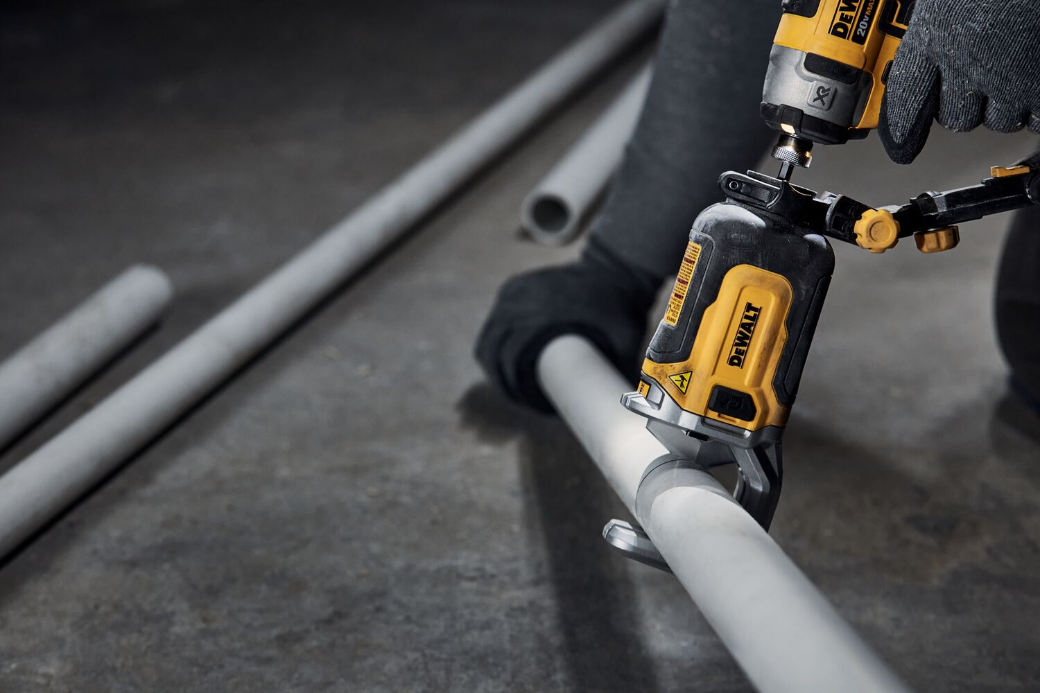 End user using DEWALT IMPACT CONNECT PVC/Pex Cutter attachment on Impact Driver to cut PVC pipe.