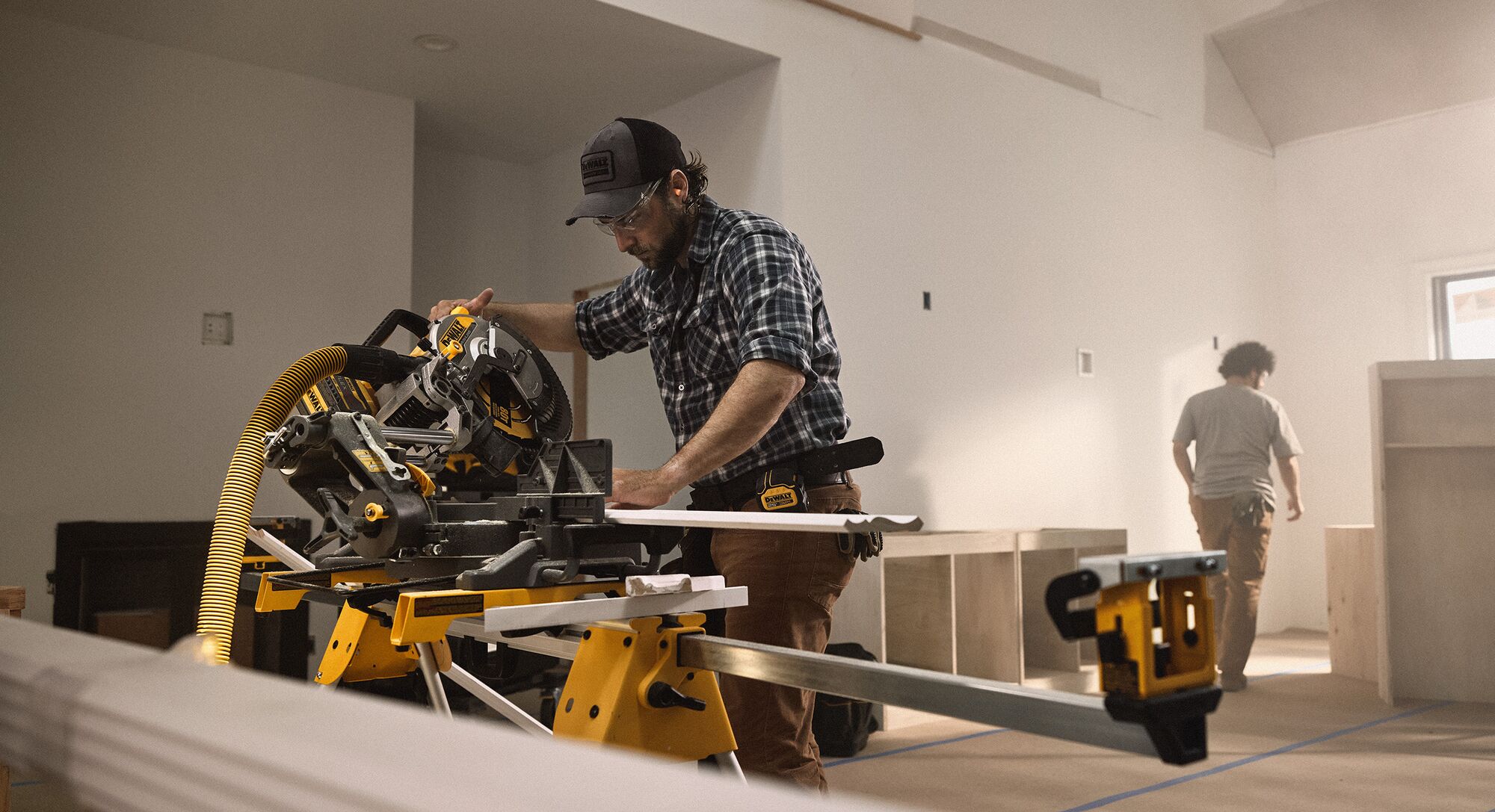 A tradesperson uses a DEWALT miter saw to cut trim pieces