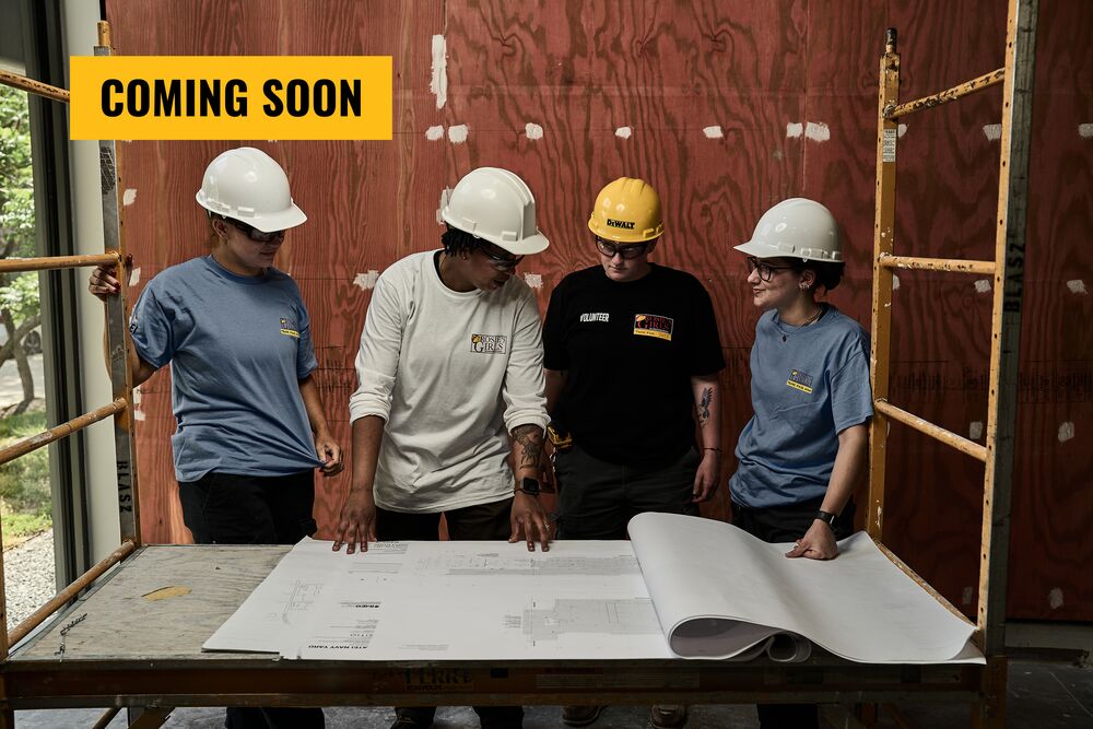 Four people in DEWALT gear discussing blueprints in an unfinished room; the words "COMING SOON" are overlayed on the image