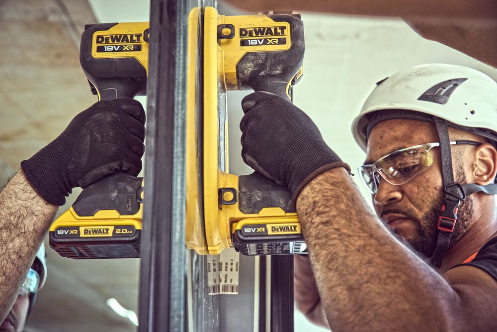 Construction worker attaches a Grabo 18V XR Suction Lifter to a pane of glass