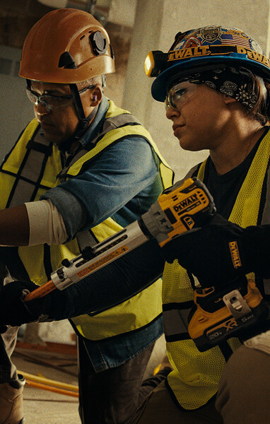 Two electricians work on a job USING DEWALT tools