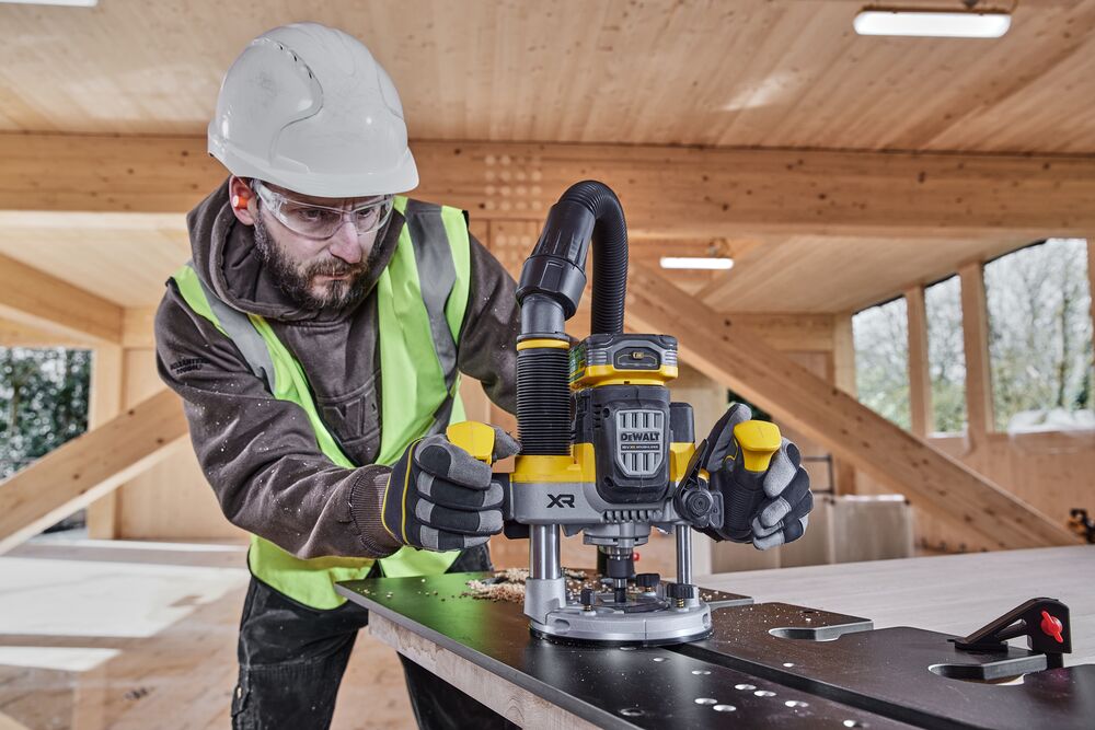 Construction worker using the 12mm plunge router on compact laminate